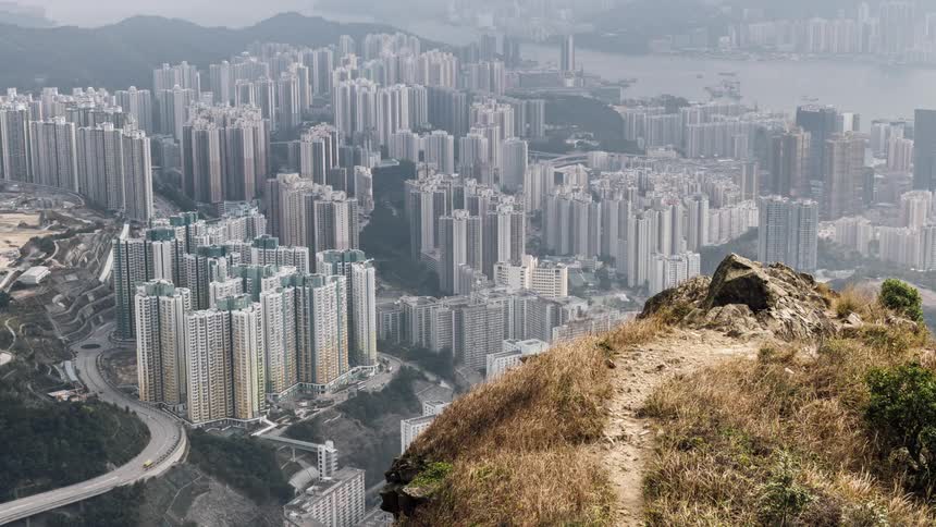 Vehicles drive on the winding roads next to the high rise buildings in the city