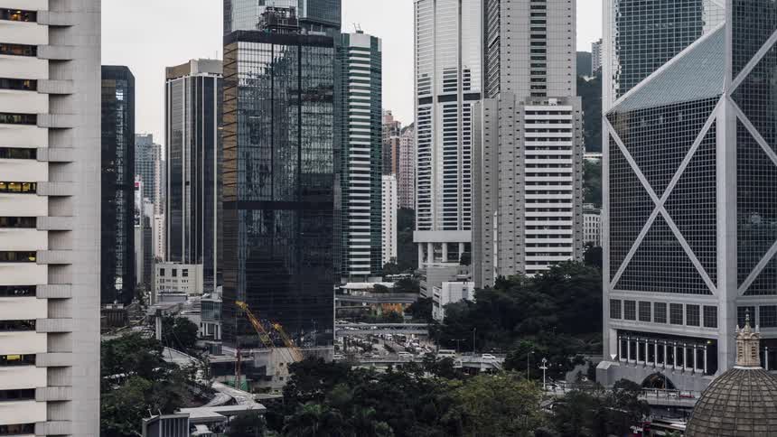 A city street with vehicles buildings and cranes