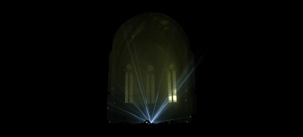 Strobe lights bounce around on the stage at a music concert