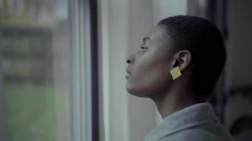 A woman stares outside through a window