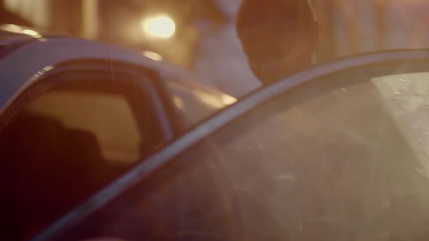 A woman walks towards her car and gets in