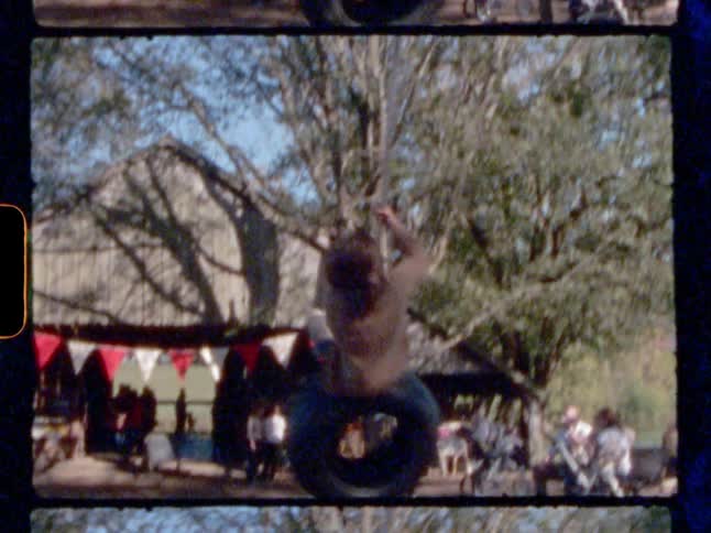 A girl swinging on top of a tire swing