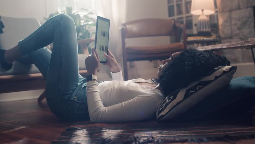 Young black woman scrolls through website on tablet