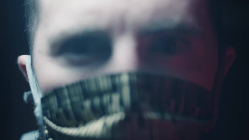 A white male puts on a gold and black face mask