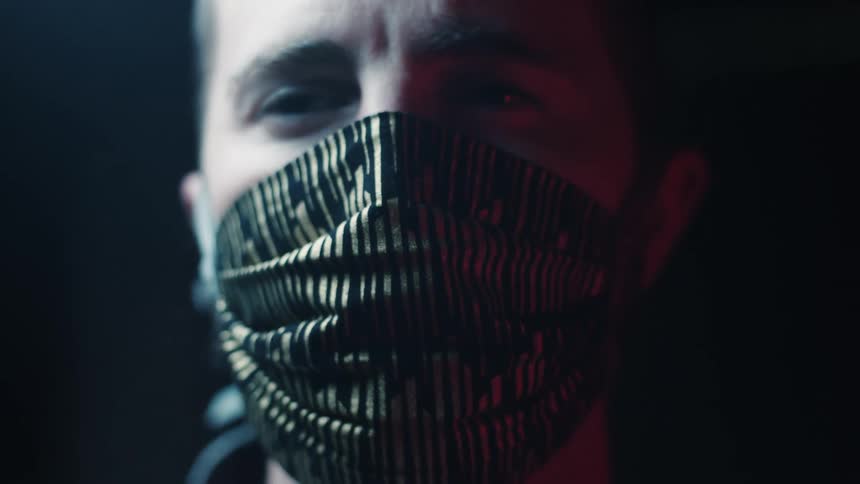 A young man wears a mask