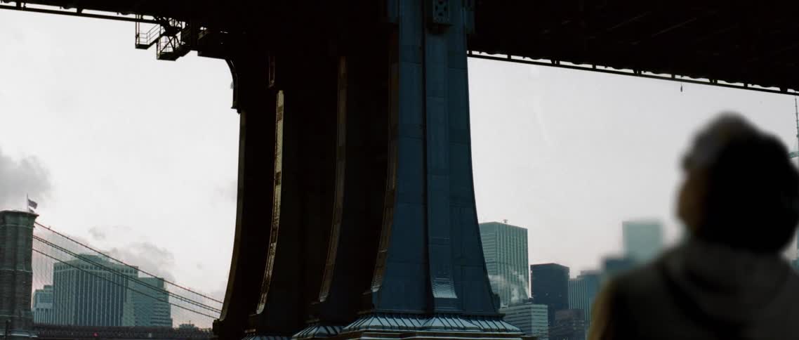 A person standing under a bridge looking up