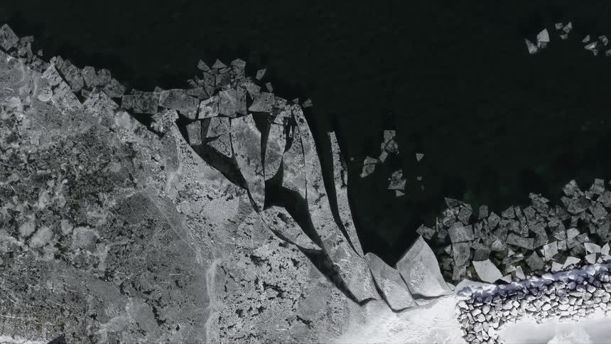 Rubble and ice cluster on shore of dark colored water