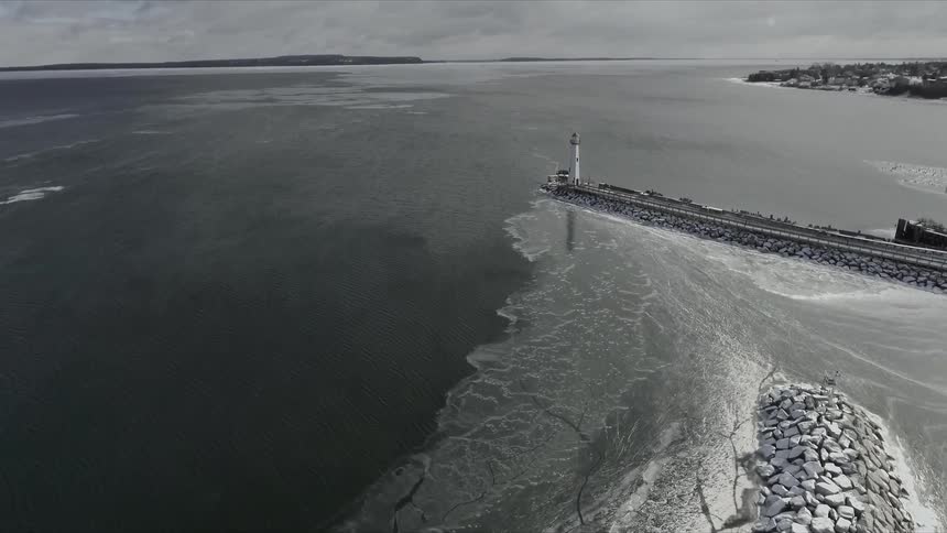 A lighthouse sits on the shoreline