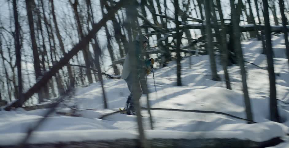 Man skis down hill in forest