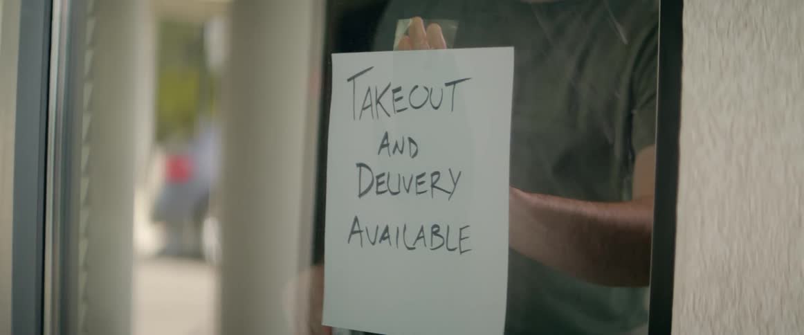 An employee at a business changes window signs