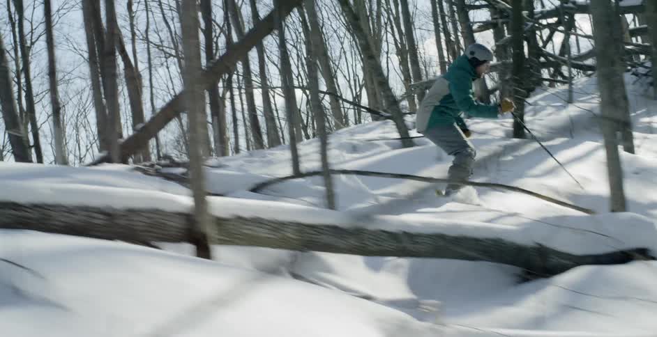 A skier skis through a snow covered forest