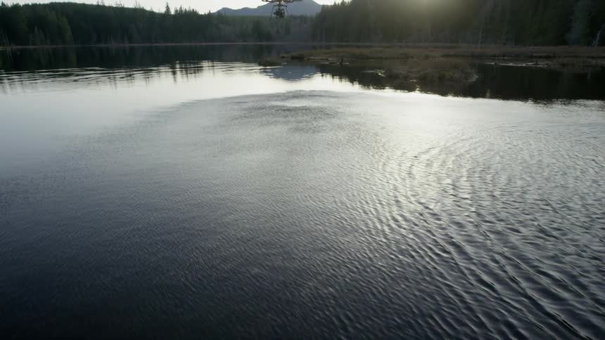 A drone flying is causing ripples in the water below