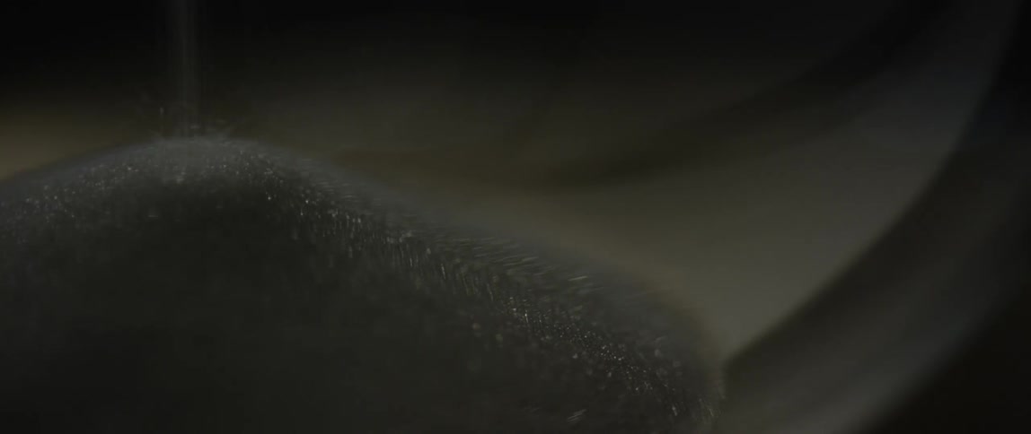 Black sand falling into a pile