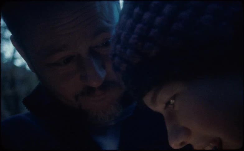 A man and woman laugh as their heads are close together