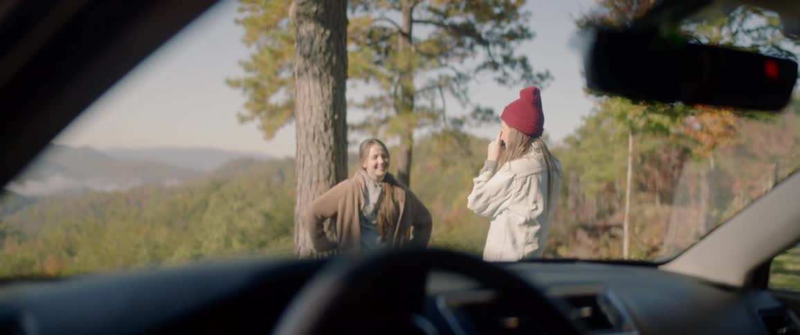 Woman takes a picture of a girl posing for photographs in the forest
