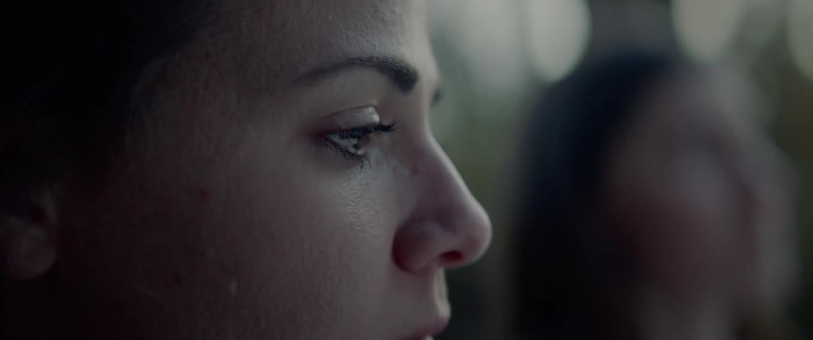 White woman crying and staring at something next to another woman