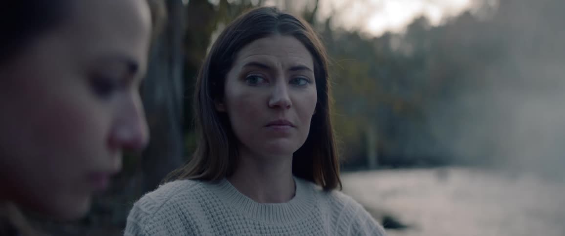 A woman stares sadly at another