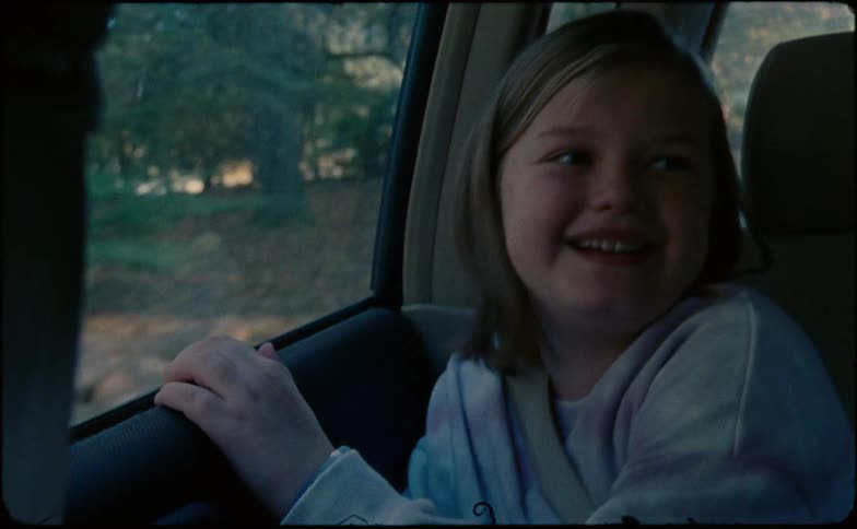 Little girl looks the window of the moving car