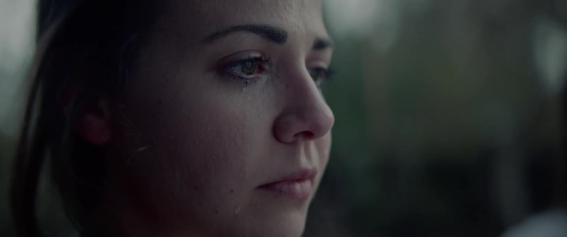 White woman crying while standing next to another woman