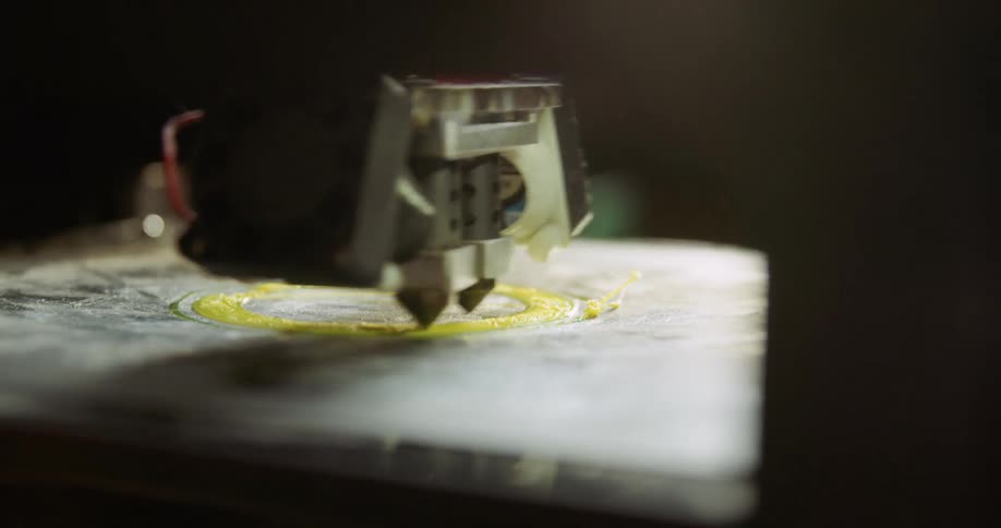 3d printing machine making a plastic yellow circular object
