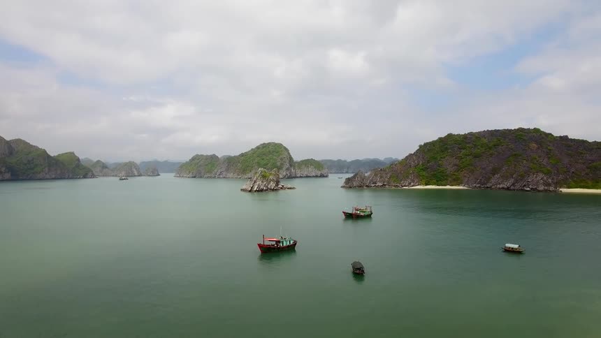 Small boats sit in a turquoise lake dotted with small islands and promontories