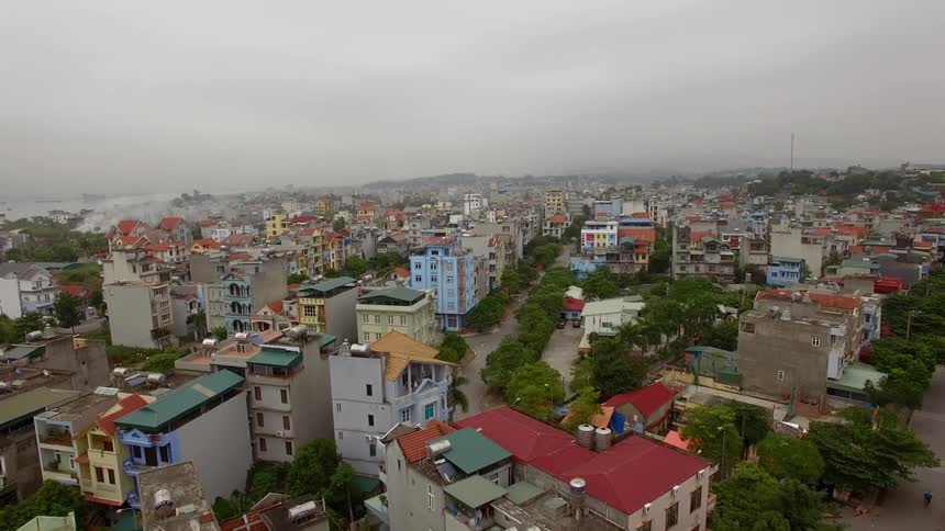 Neighborhood buildings sit under a cloudy sky