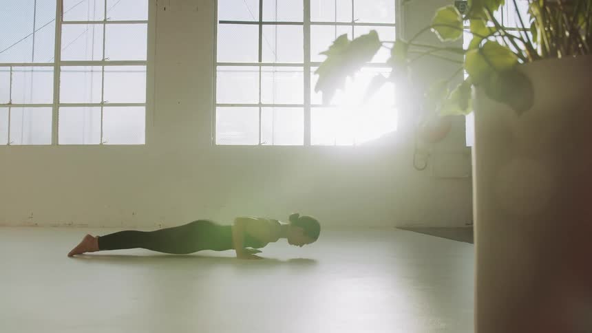 Woman exercises in a room without furniture