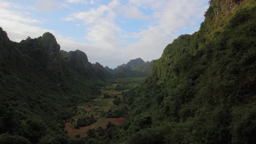 Aerial view of a valley between grassy mountains