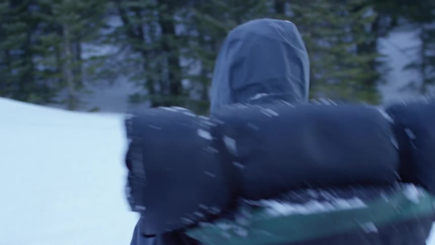 A backpacker walks through snow