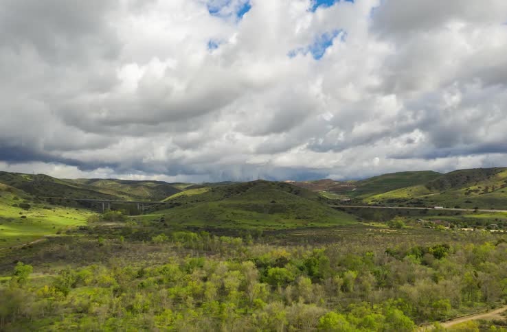 Rolling clouds over a hilly landscape
