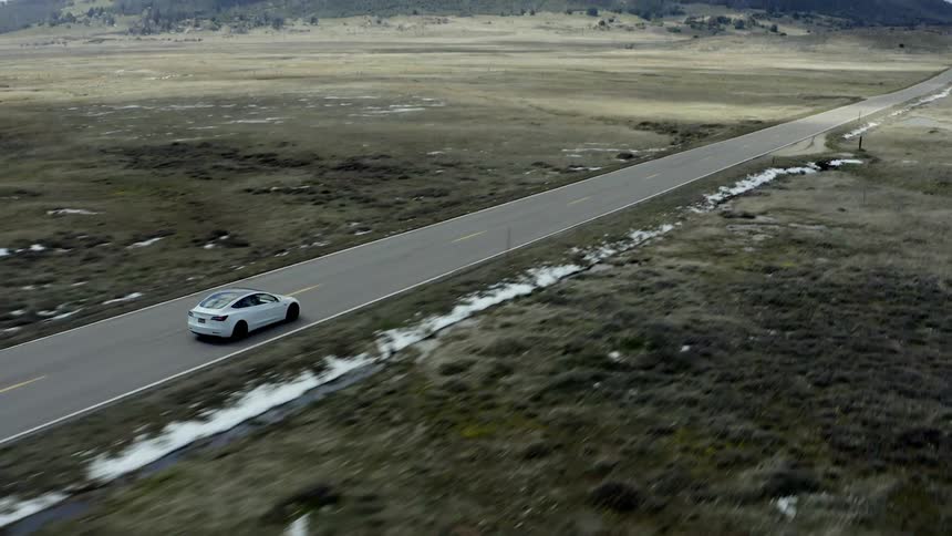 A sedan being driven on a mountain road