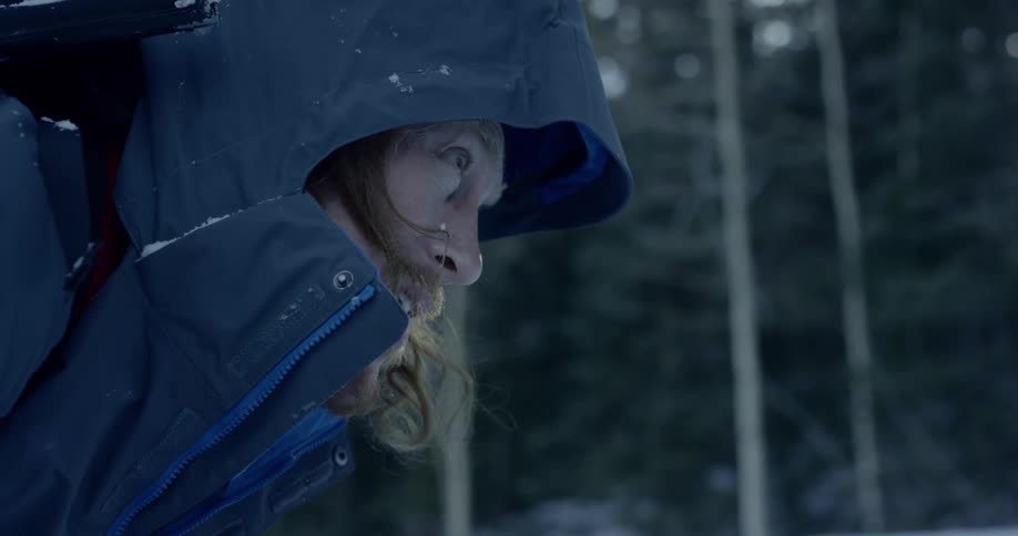Man walks barely through snow in the forest