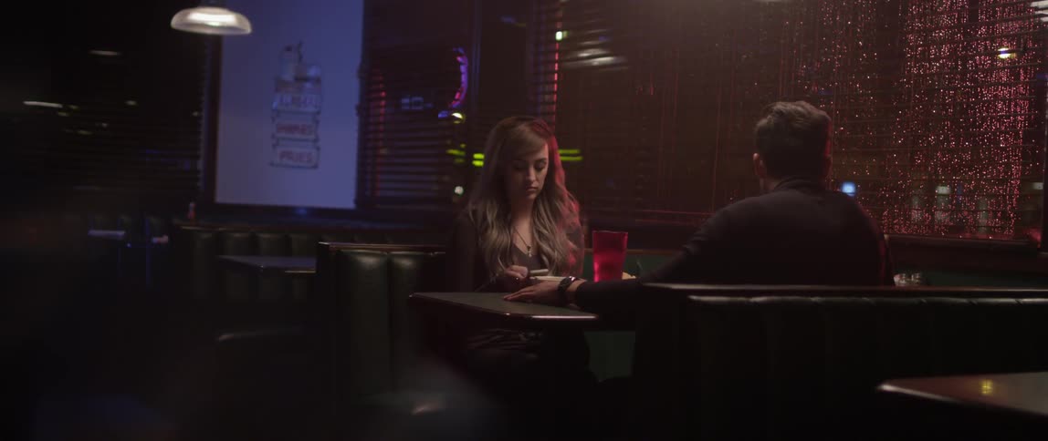 A couple sitting in a restaurant booth