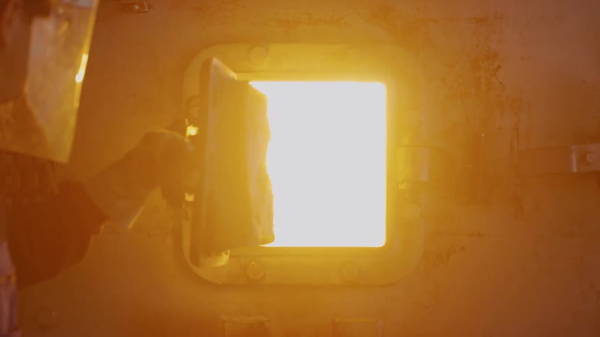 A man opens the door to the hot furnace