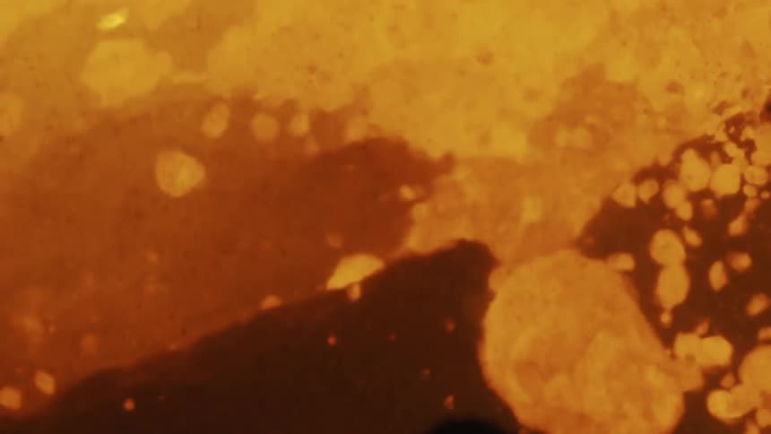 Yellow shapes that look like lit charcoals falling