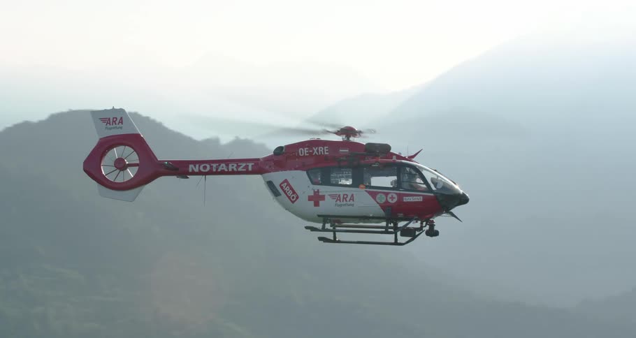 Rescue helicopter hovering through the mountains in slow motion