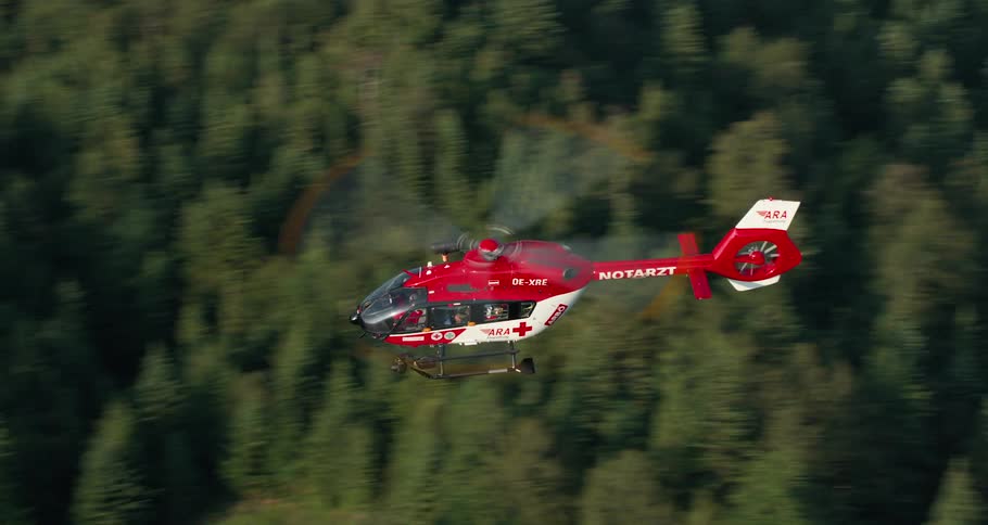 The emergency helicopter flies over the forest