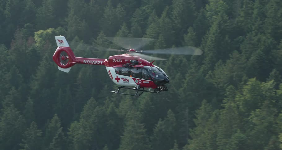 First aid helicopter flying above a forest