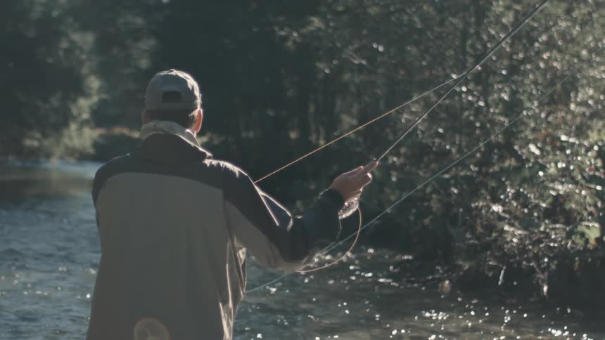 Man tries to catch fish from a river