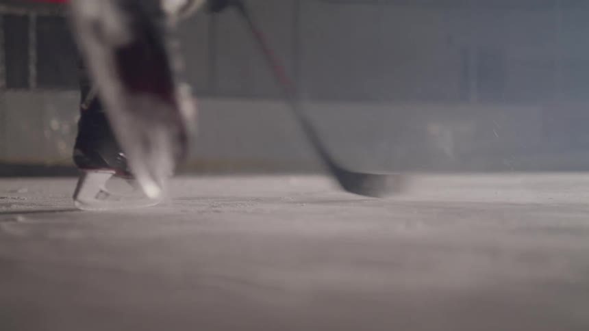 A hockey player hits a puck into the goal
