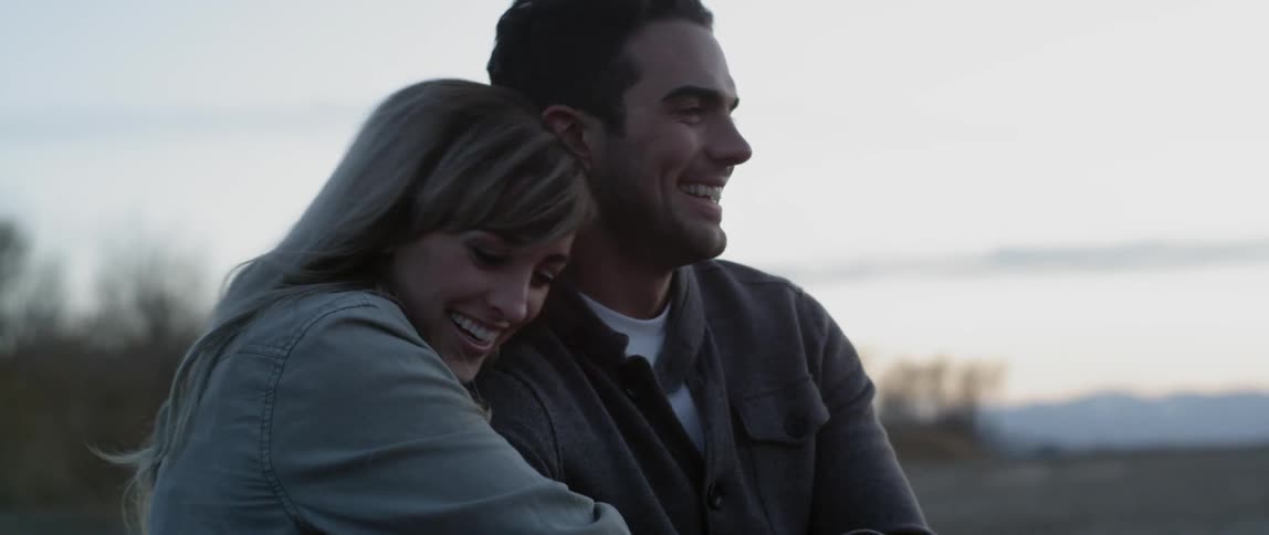A man and woman are talking as they sit outside on a cloudy day