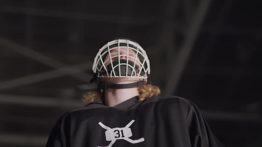 A hockey player stands in an ice rink