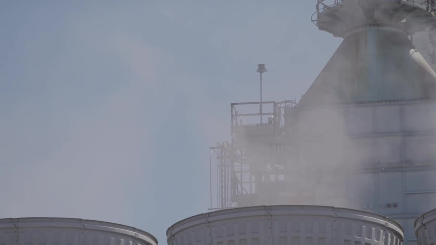 Steam and smoke rise up from a factory