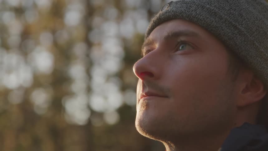 A man stands outside and looks off in to the distance