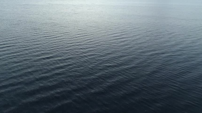 The rippling ocean water sits under the bright sun
