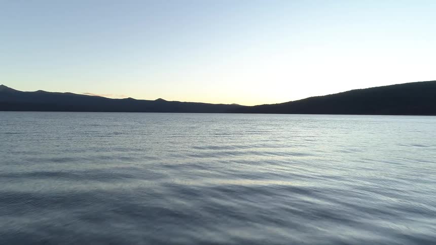 Man with backpack walking along a lake
