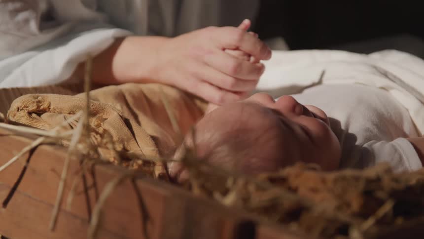 A parent holds their babies hand