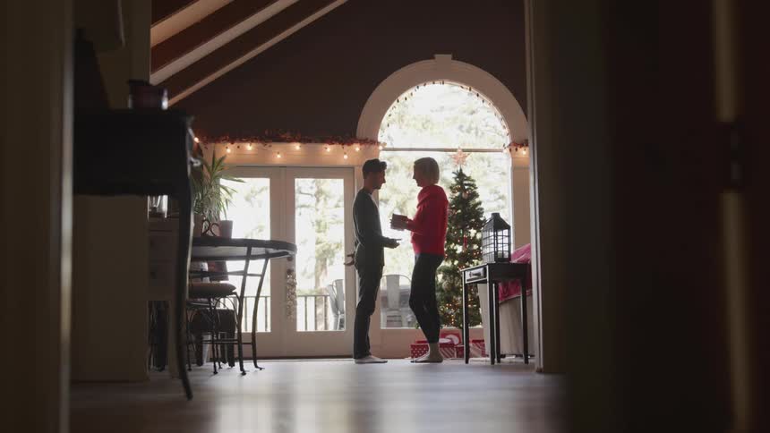 Man giving his wife a gift for christmas inside the house