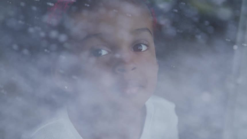 Young black child watches the snowflakes fall