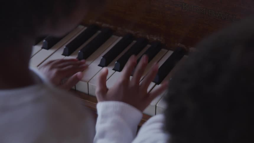 Black children press the piano keys randomly